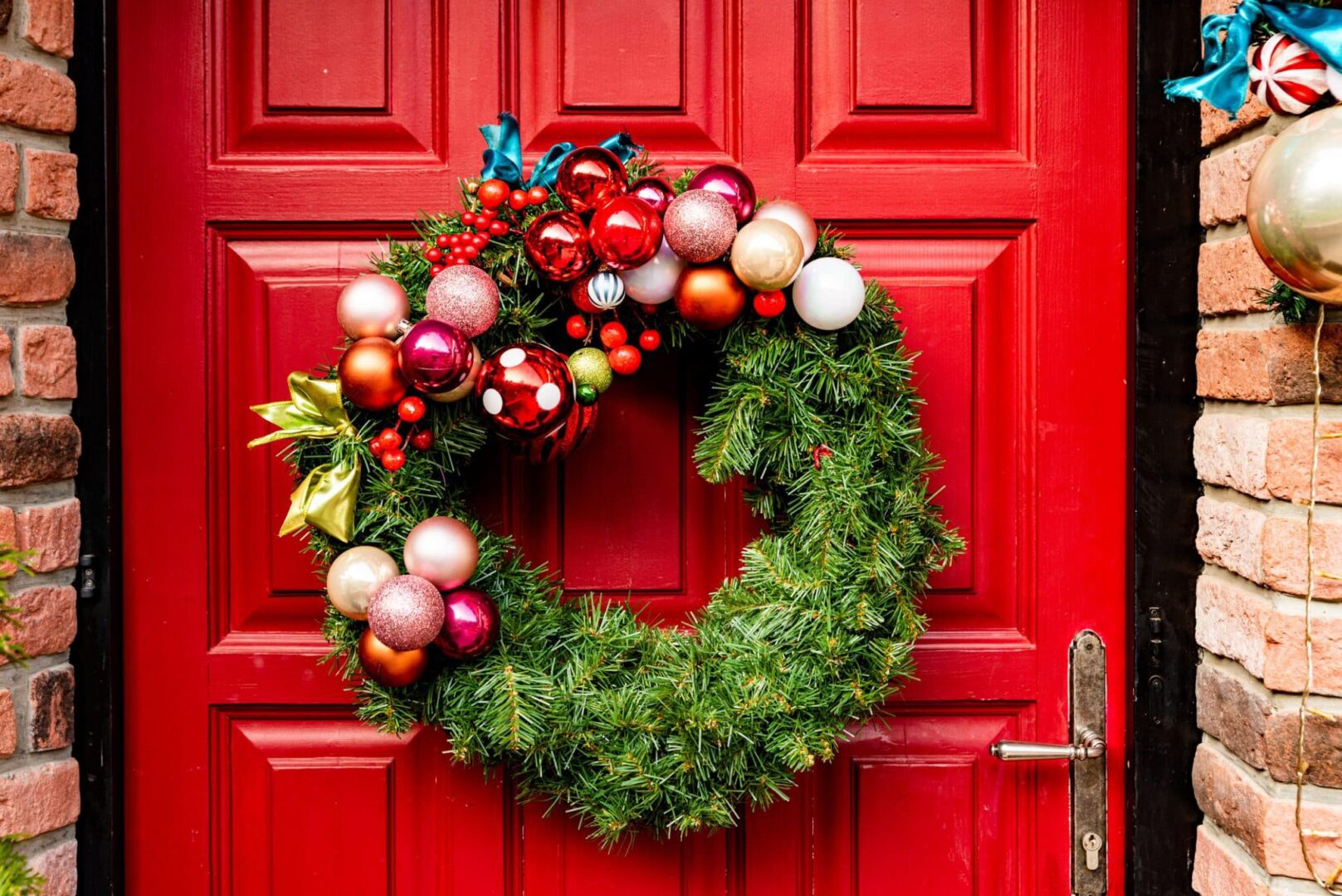 A wreath on the front door of a red house.